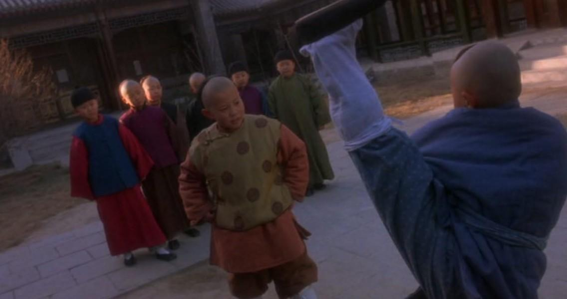 Jungen in traditioneller chinesischer Kleidung üben draußen Kampfkünste.