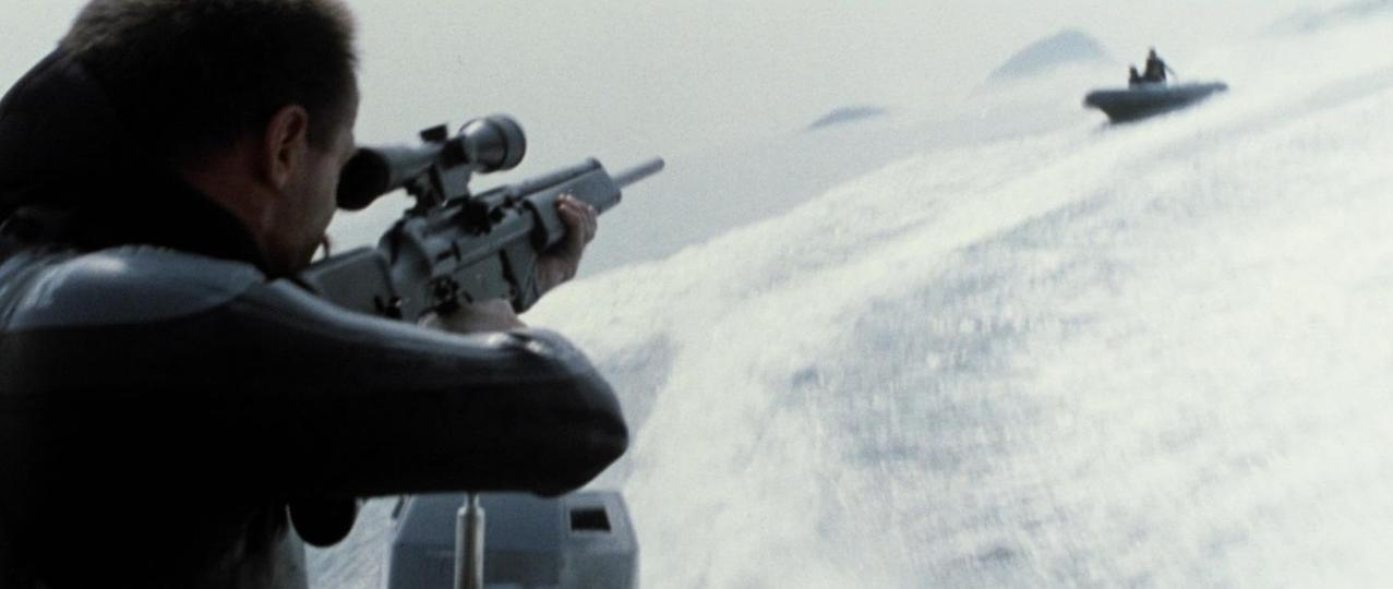 Mann zielt mit Gewehr auf Boot in verschneiter Landschaft.