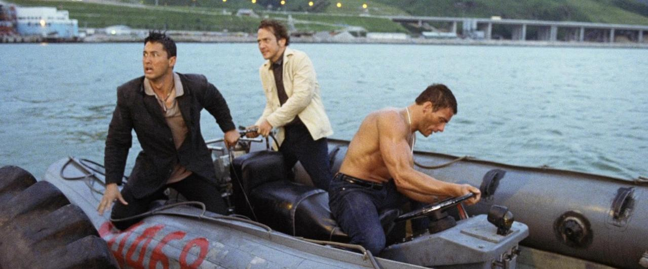 Drei Männer in einem Schlauchboot auf dem Wasser. Einer steuert, die anderen schauen.