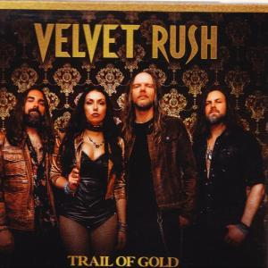 Die Band Velvet Rush posiert vor einer verzierten goldenen Tapete mit dem Albumtitel Trail of Gold.