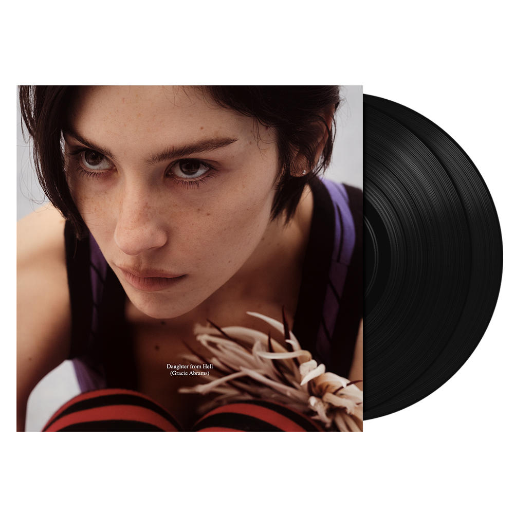 Junges Mädchen mit dunklem Haar, lila Weste, schwarze Schallplatten im Vordergrund.