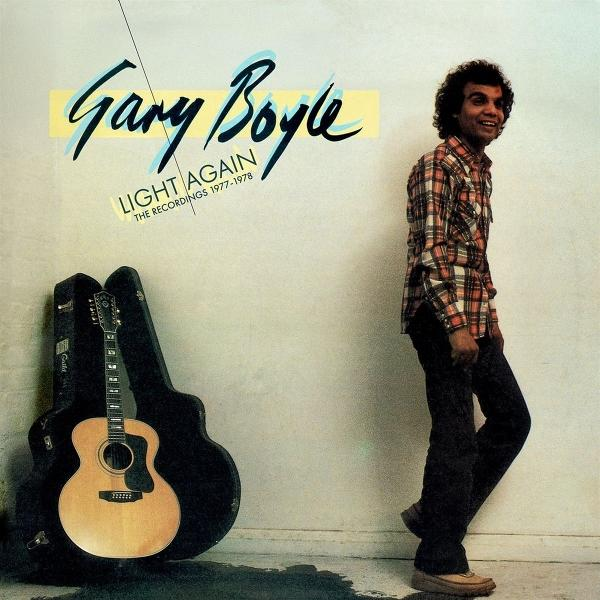 Ein Mann mit kariertem Hemd steht neben einer Gitarre im Koffer. "Gary Boyle" steht oben.
