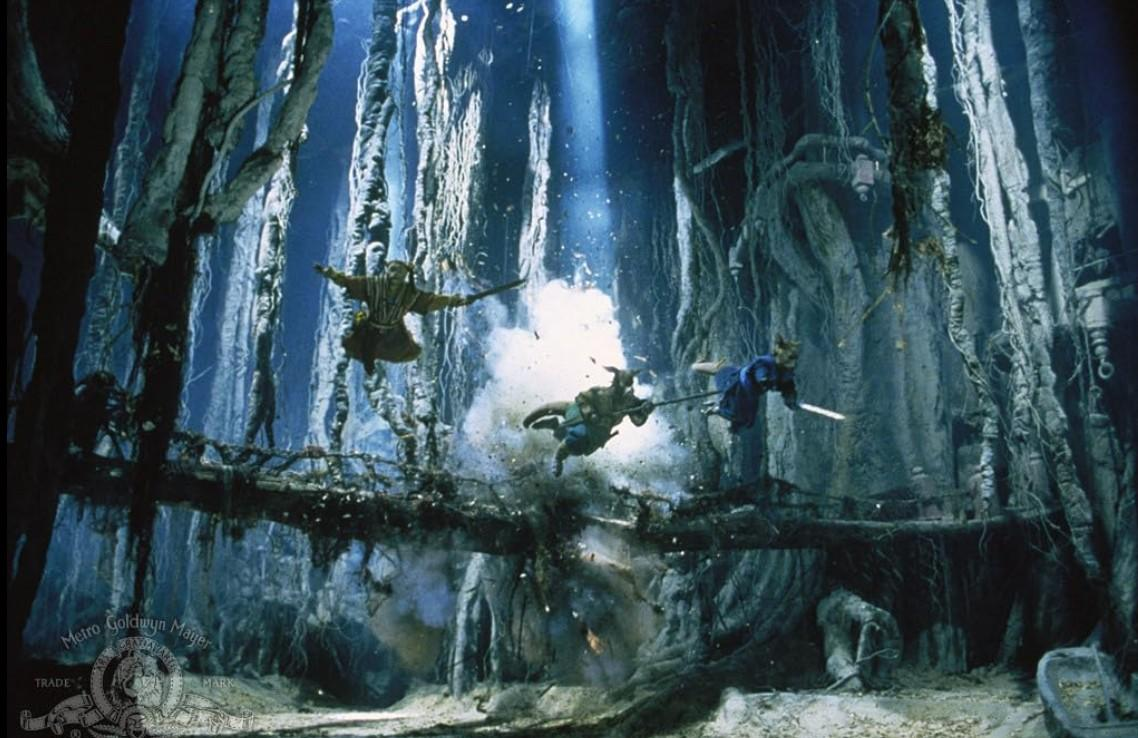 Drei Krieger springen in der Luft, umgeben von Bäumen und Trümmern.