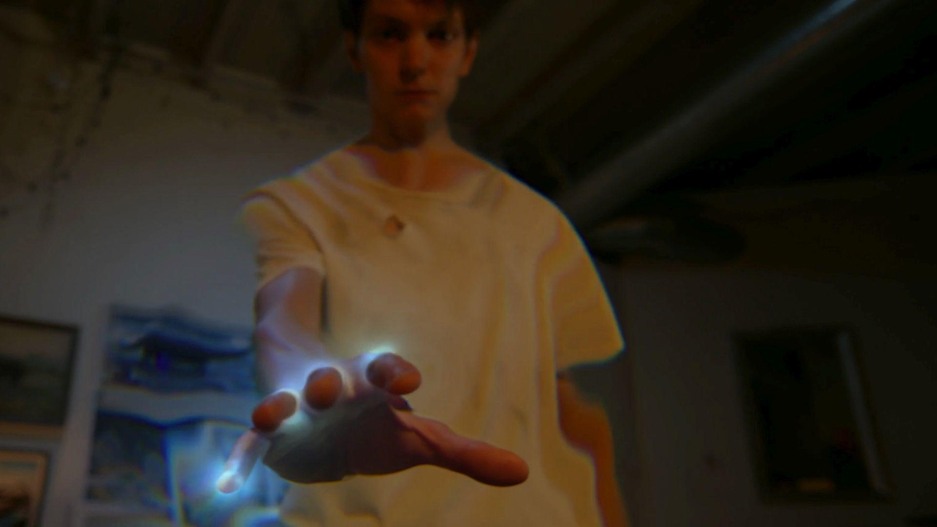 Ein Mann streckt seine Hand aus, aus der blaues Licht strömt.