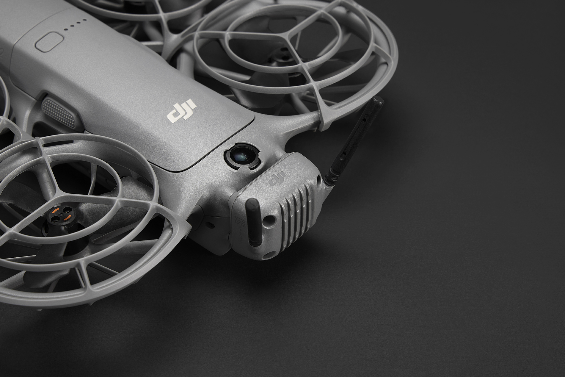 Koyu yüzeyde pervaneleri ve kamerası olan gri drone.