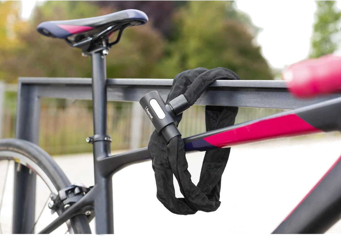 Czarna blokada rowerowa zabezpiecza rower do metalowej balustrady.