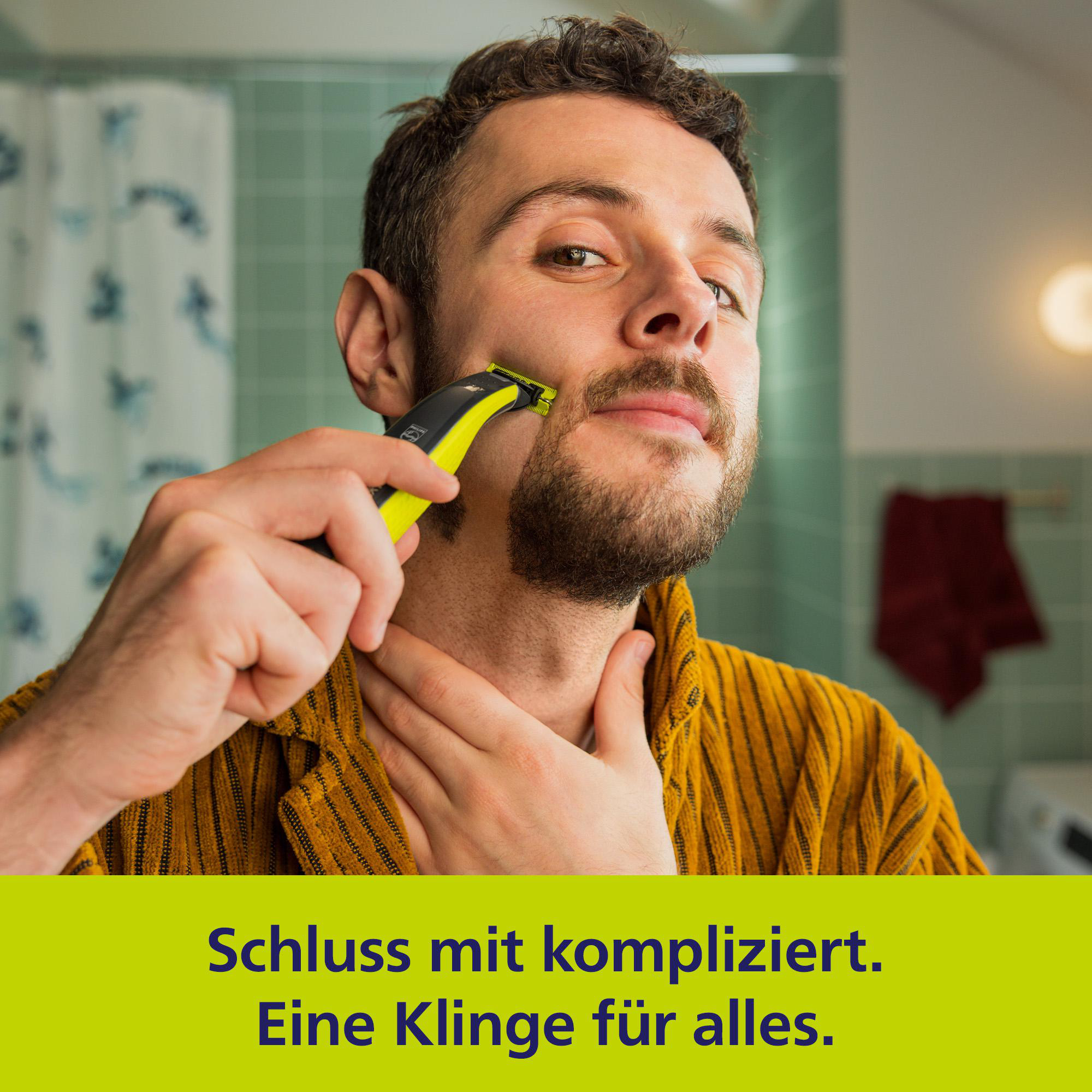 Mann rasiert sich mit einem gelben Trimmer im Badezimmer.