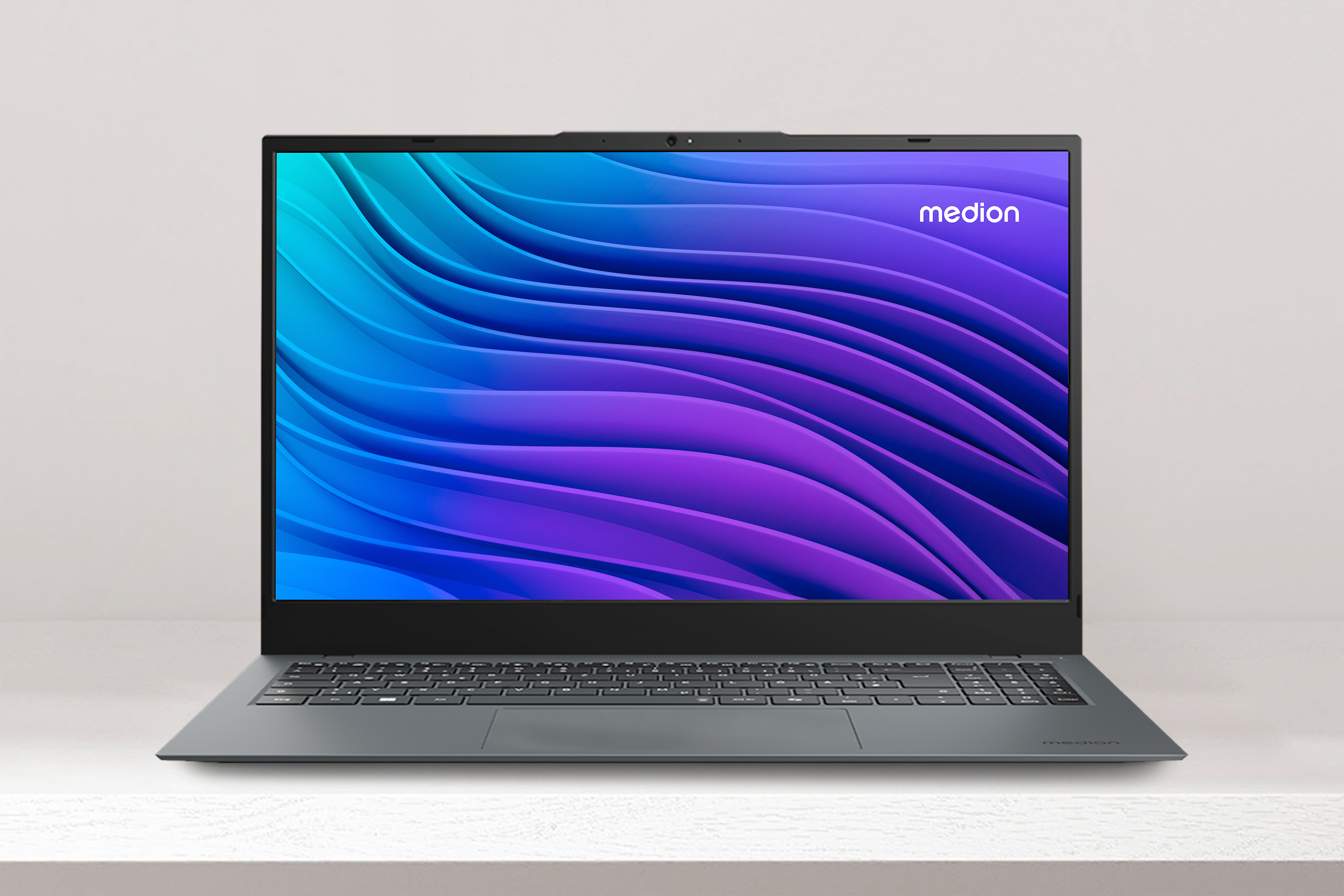 Een open grijze laptop met een blauwe en paarse golvende achtergrond.