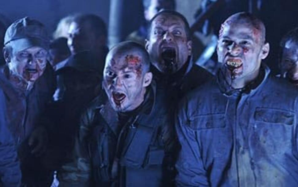 Eine Gruppe von Zombies mit blutverschmierten Gesichtern und offenen Mündern.
