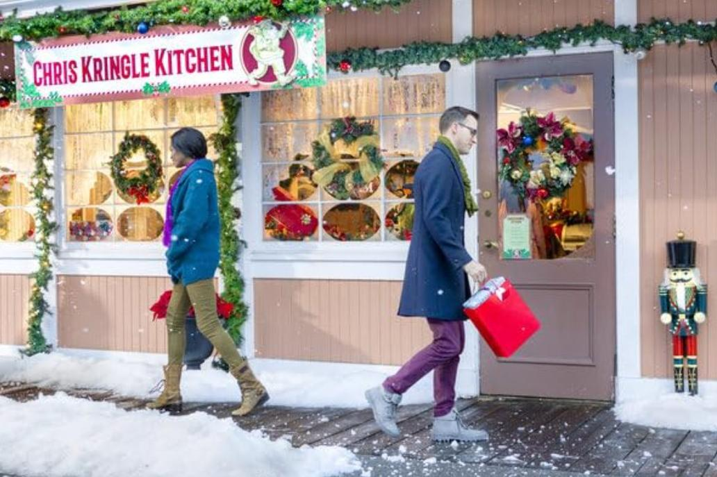 Geschmückter Laden "Chris Kringle Kitchen" mit zwei Personen und Schnee.