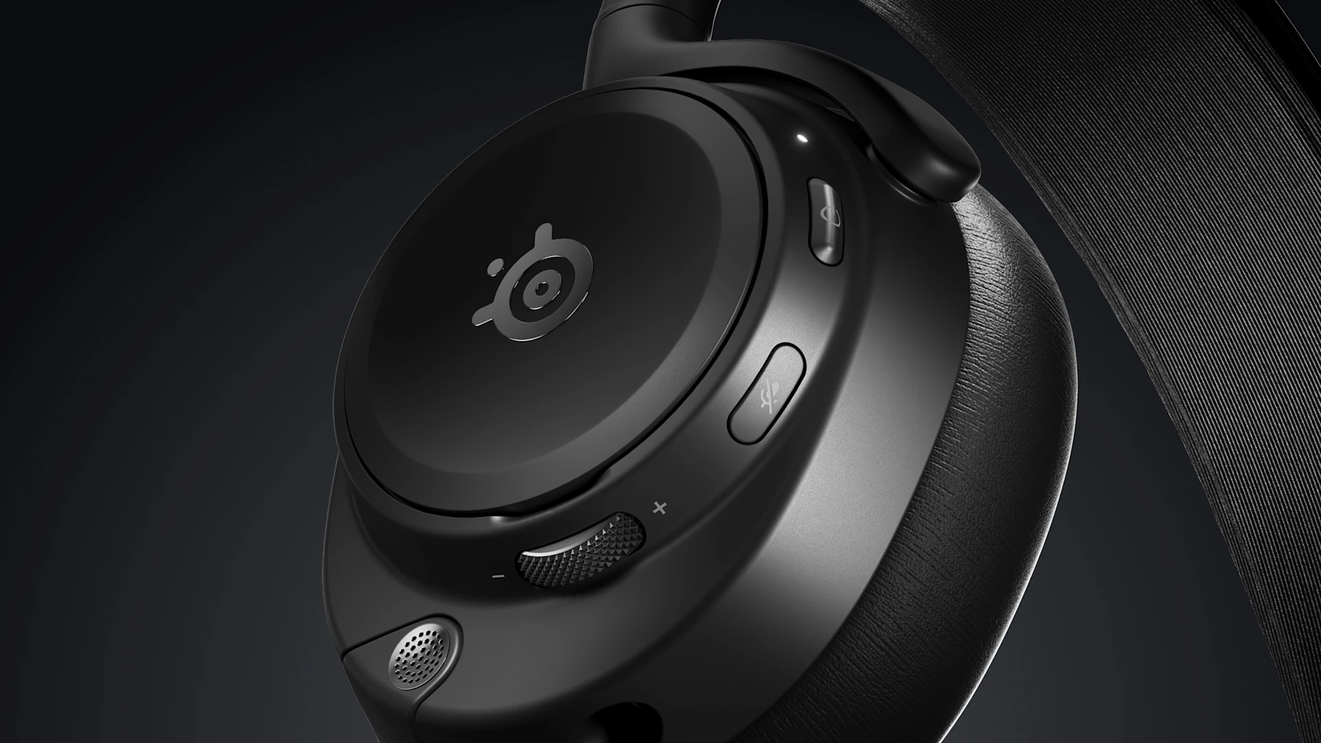 Primer plano de la copa del oído de un auricular para juegos negro con botones y rueda de volumen.