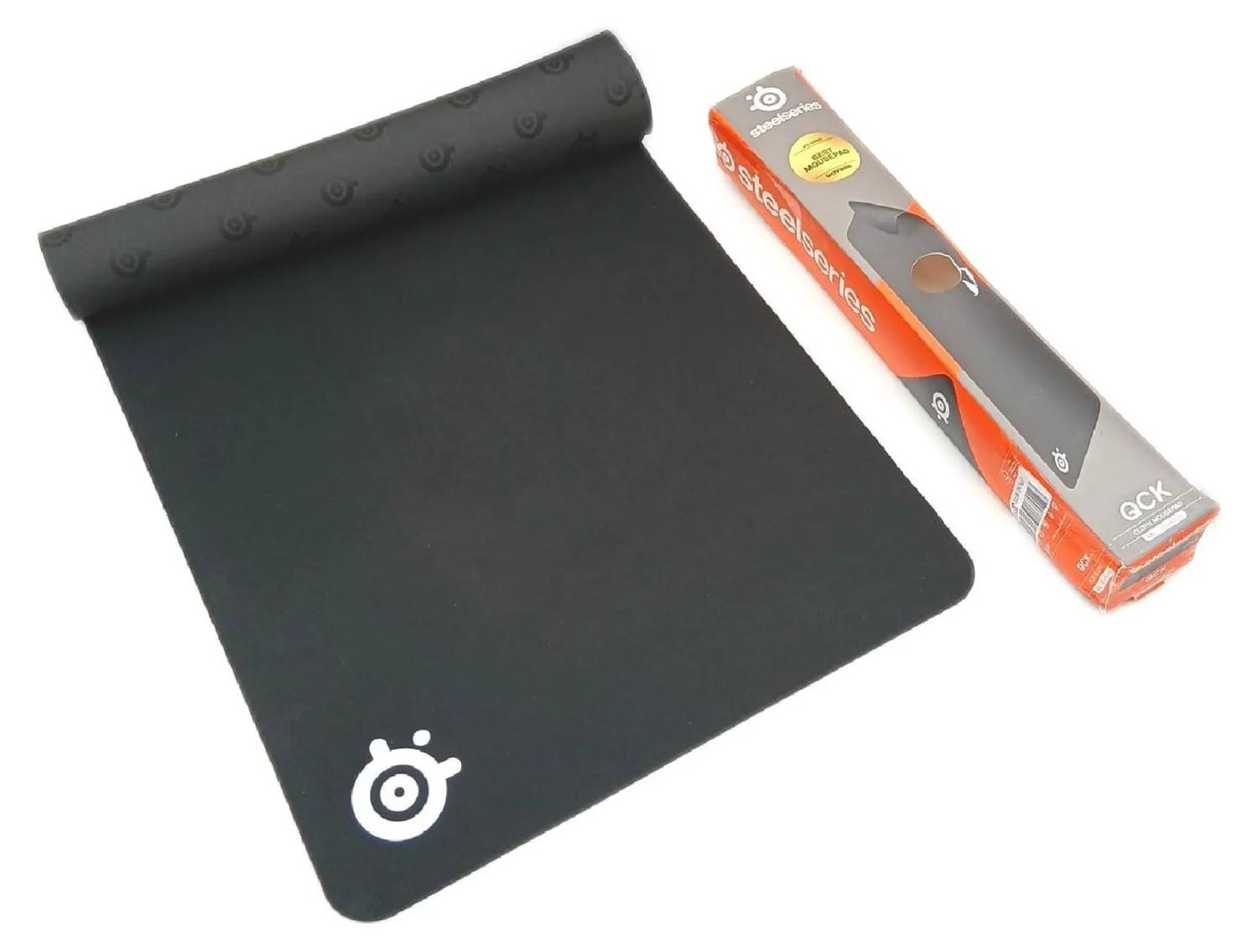 Alfombrilla de ratón SteelSeries QCK negra con embalaje sobre fondo blanco.