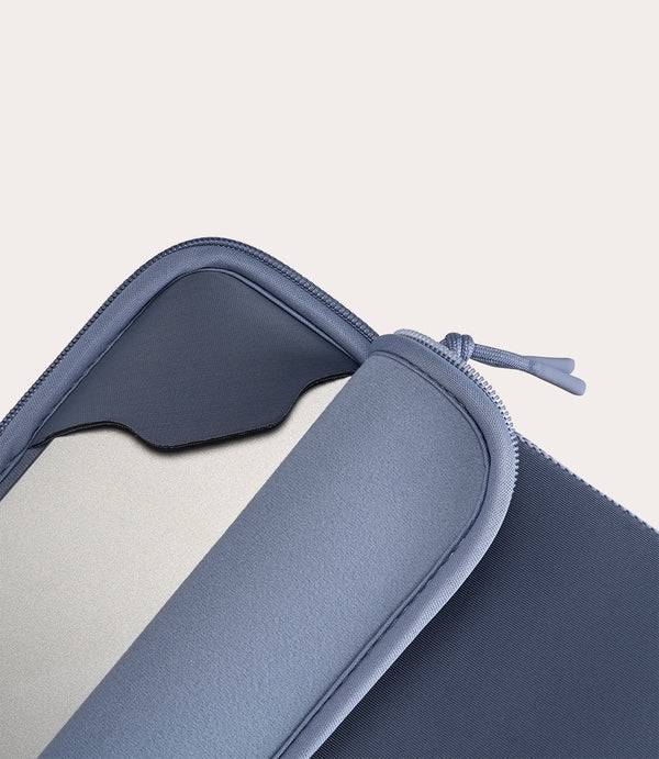 Funda azul para portátil con cremallera y cordón, interior gris claro.