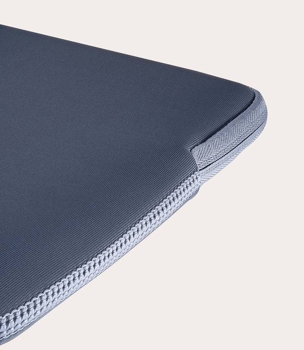 Funda gris para portátil con cremallera y detalles de costura.