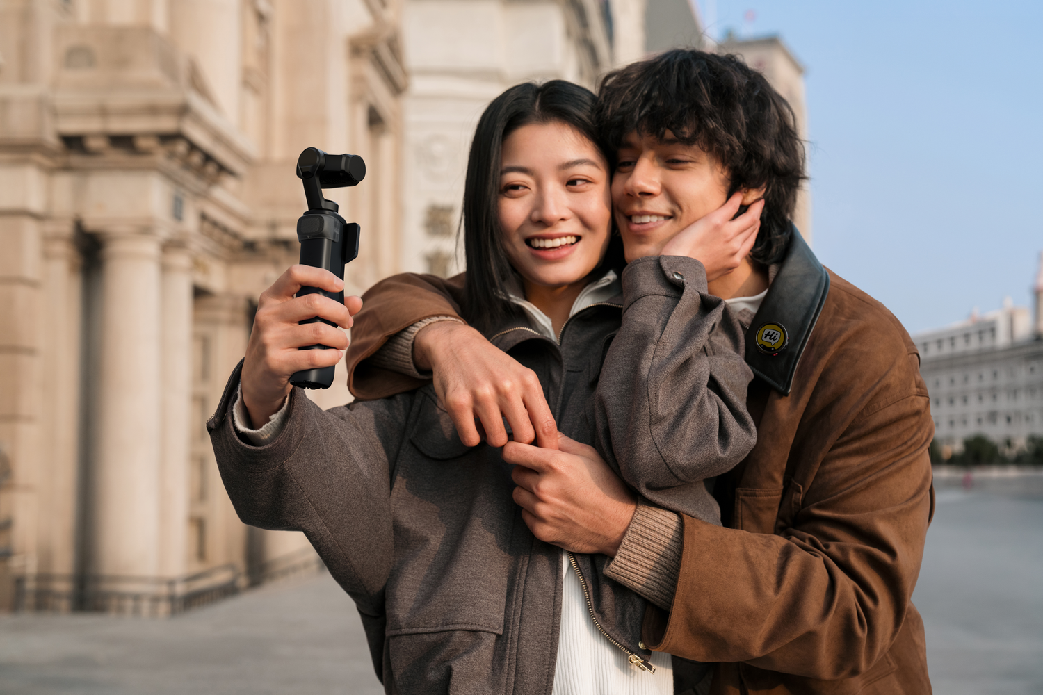 Una pareja joven se toma una selfie frente a un edificio.