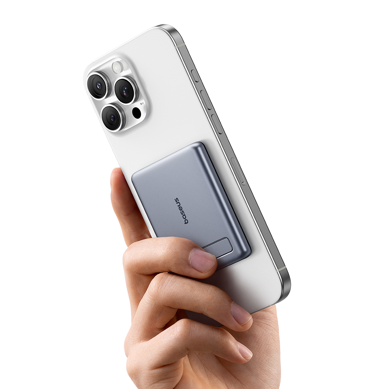 Una mano sostiene un smartphone blanco con una bater ía externa magnética gris adherida.