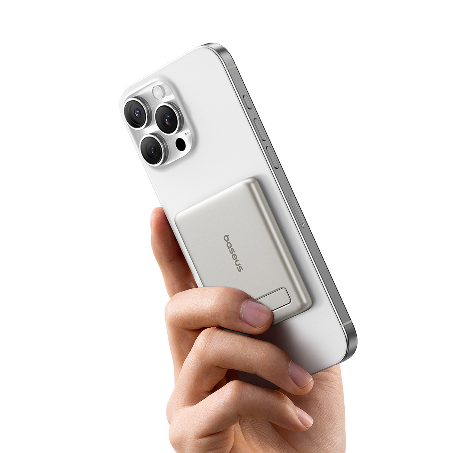 Una mano sostiene un smartphone blanco con una batería MagSafe plateada y el logo de Baseus.