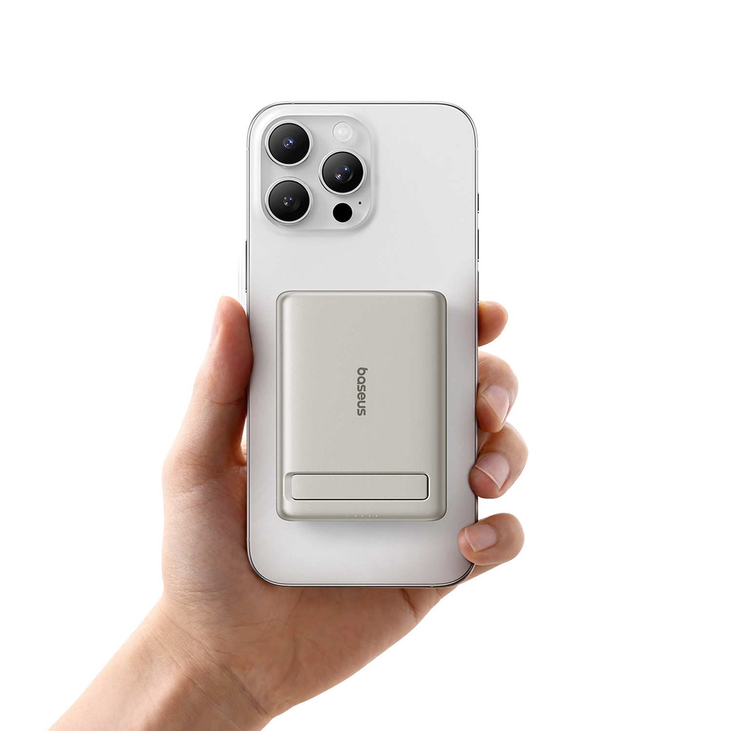 Una mano sostiene un smartphone blanco con una batería externa plateada en la parte trasera.