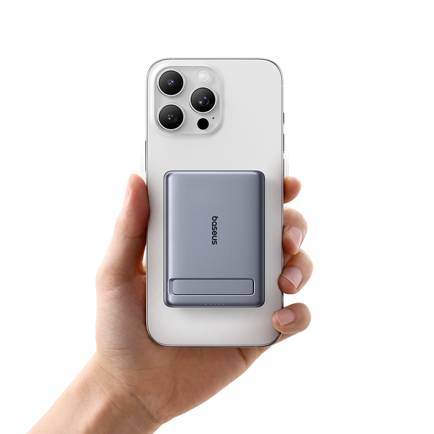 Mano sostiene un teléfono inteligente plateado con una batería magnética gris adjunta.