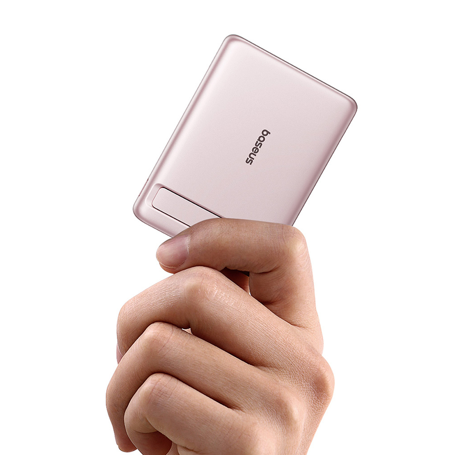 Una mano sostiene un dispositivo Baseus rosa sobre fondo blanco.