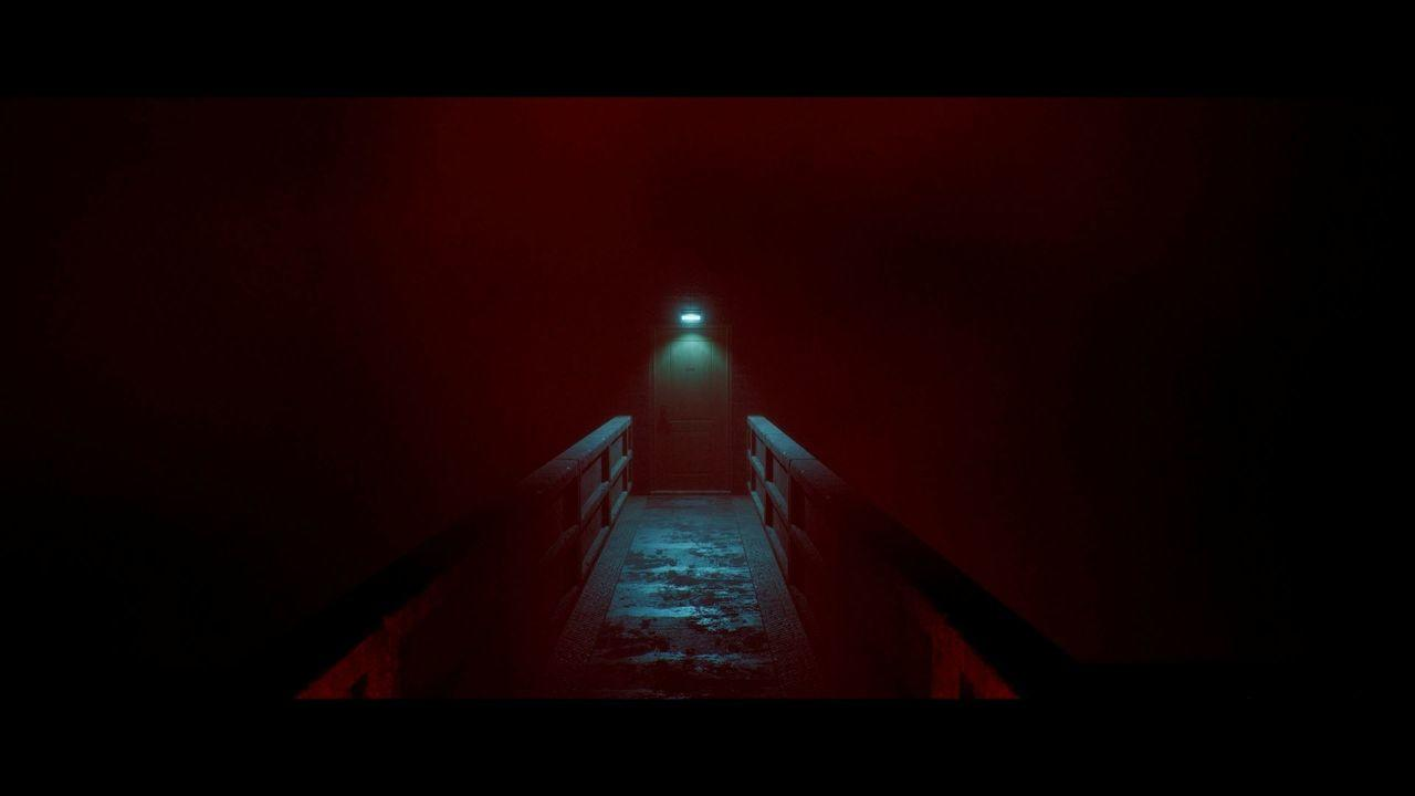 Ein dunkler Steg führt zu einer Tür, beleuchtet von einer Lampe.