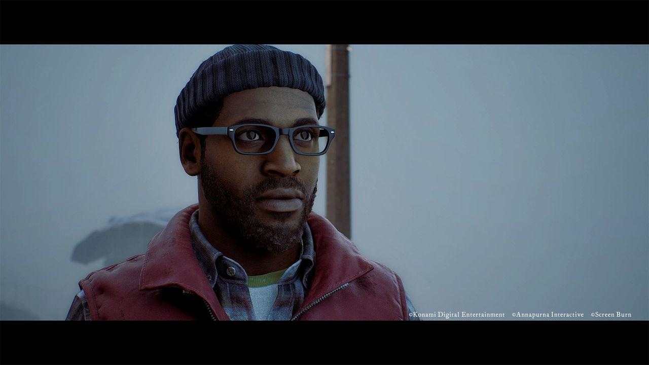 Ein Mann mit Brille und Mütze trägt eine rote Weste über einem karierten Hemd.