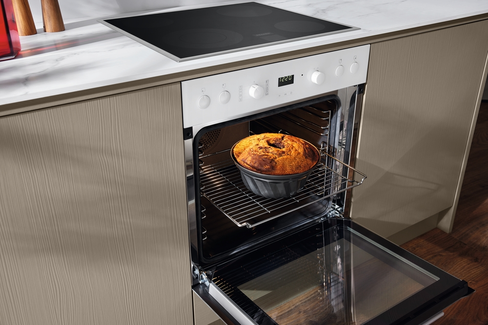 Ein Kuchen wird in einem offenen Ofen auf einem Rost gebacken.