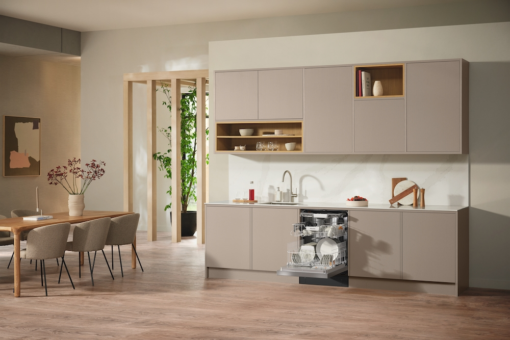 Moderne Küche mit geöffnetem Geschirrspüler, Essbereich und Pflanzen.