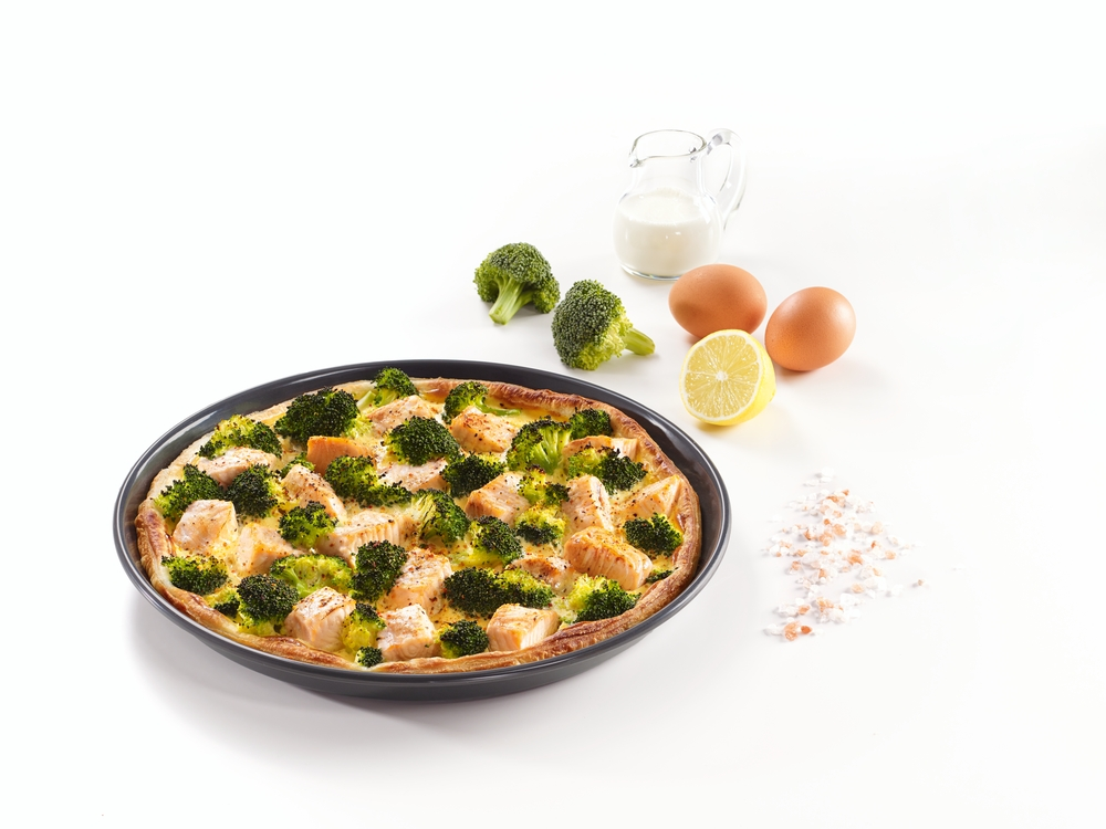 Herzhafter Kuchen mit Lachs, Brokkoli und Eiern, garniert mit Zitrone.