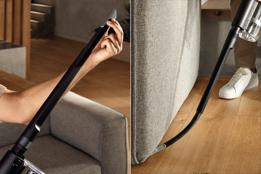 Person reinigt Sofa mit Staubsaugerrohr, Nahaufnahme.