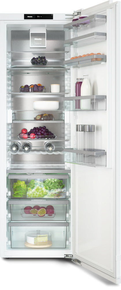 Offener Kühlschrank mit Obst, Eiern und Käse auf mehreren Ebenen.