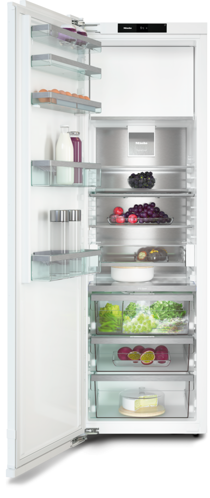Offener weißer Miele-Kühlschrank mit Fächern für Eier, Milch, Trauben, Obst, Gemüse und Käse.