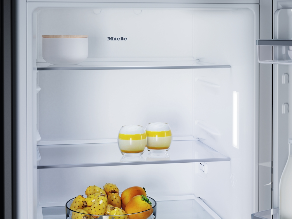 In einem Miele Kühlschrank: eine weiße Schüssel, zwei Desserts und eine Schüssel Kaktusfeigen.