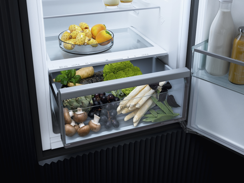 Offenes Kühlschublade mit Kaktusfeigen, Pfirsichen, Pastinaken, Brokkoli, Pilzen, Trauben, Spargel und Zuckerschoten.