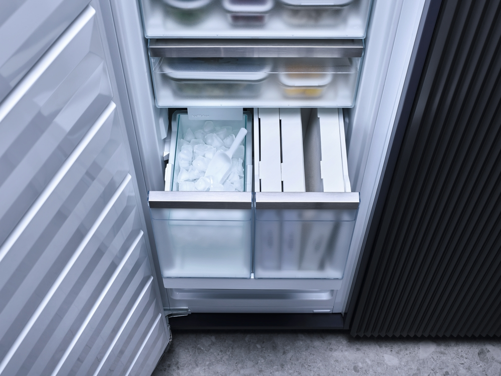 Gefrierschrank mit Eiswürfeln und Schaufel in einer Schublade.