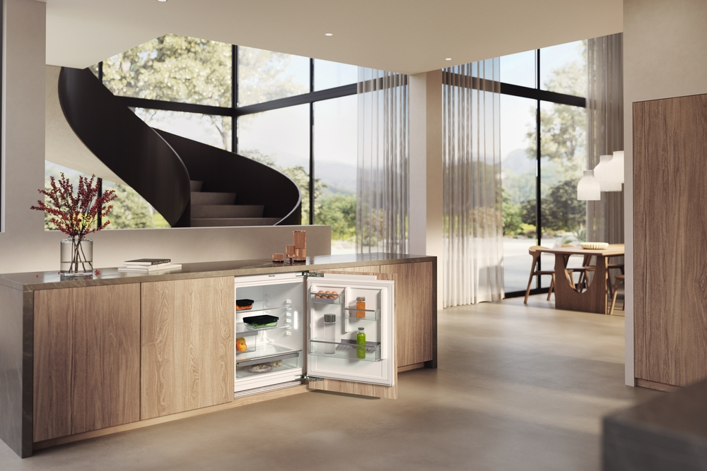 Ein moderner Küchenbereich mit offenem Kühlschrank, Wendeltreppe und Essbereich.