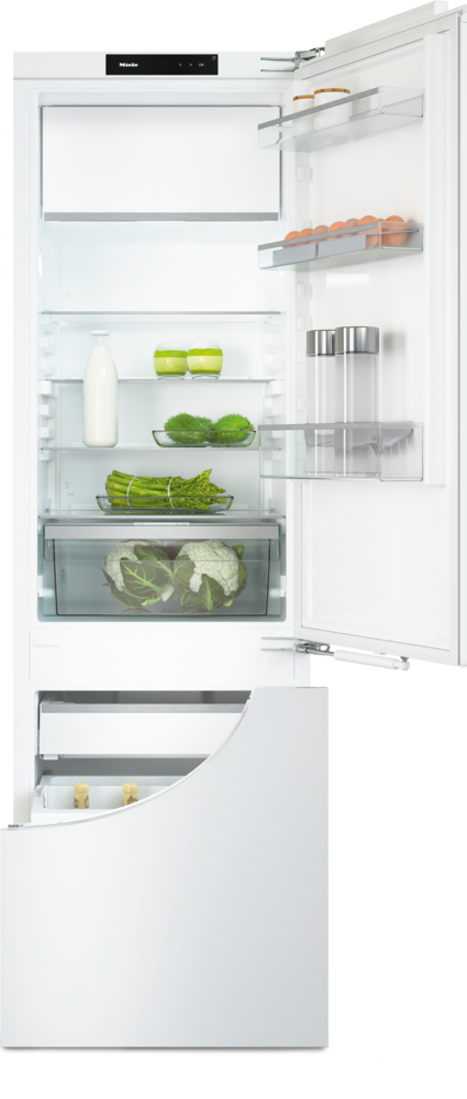 Ein offener Kühlschrank mit Eiern, Gemüse und Milchflaschen.