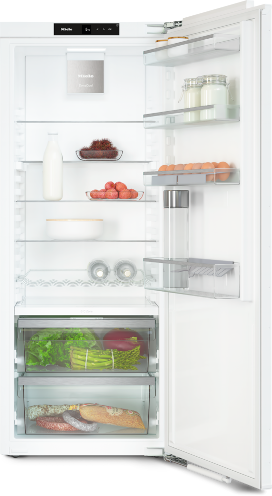Ein offener weißer Kühlschrank mit Lebensmitteln: Milch, Eier, Gemüse und Fleisch.