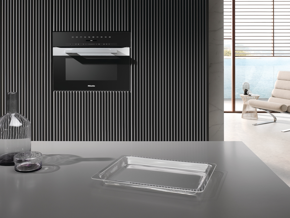 Moderne Küche mit schwarzer vertikaler Wand, Einbaubackofen und durchsichtiger Schale.