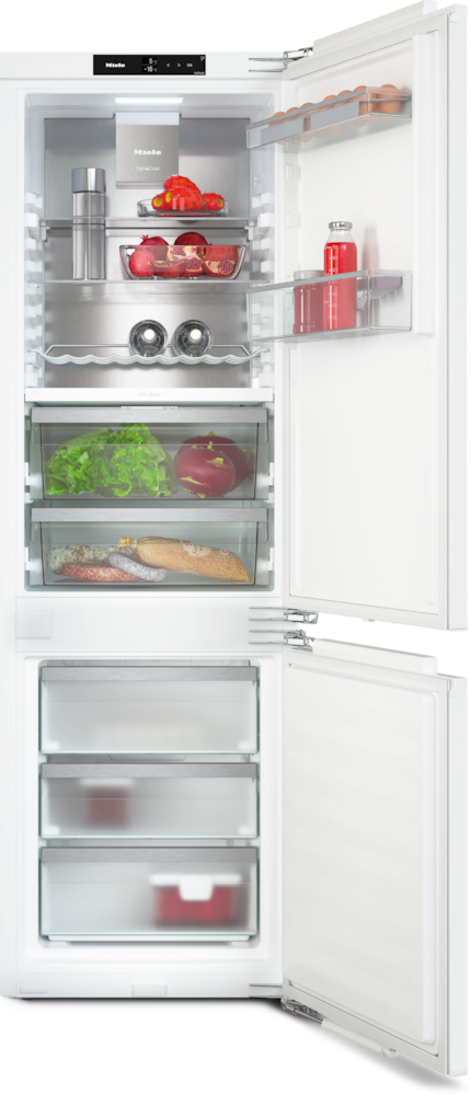 Ein offener weißer Kühlschrank mit Lebensmitteln: Eier, Tomaten, Salat, Fleisch und Flaschen.