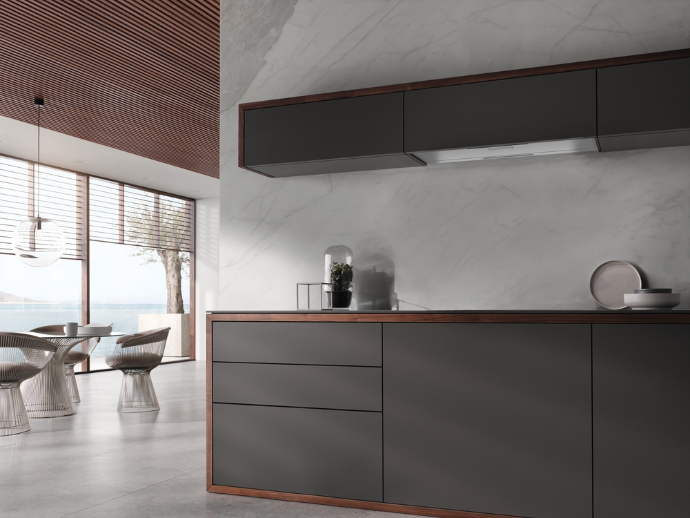 Moderne Küche mit grauen Schränken, Holzakzenten und Marmorwand.