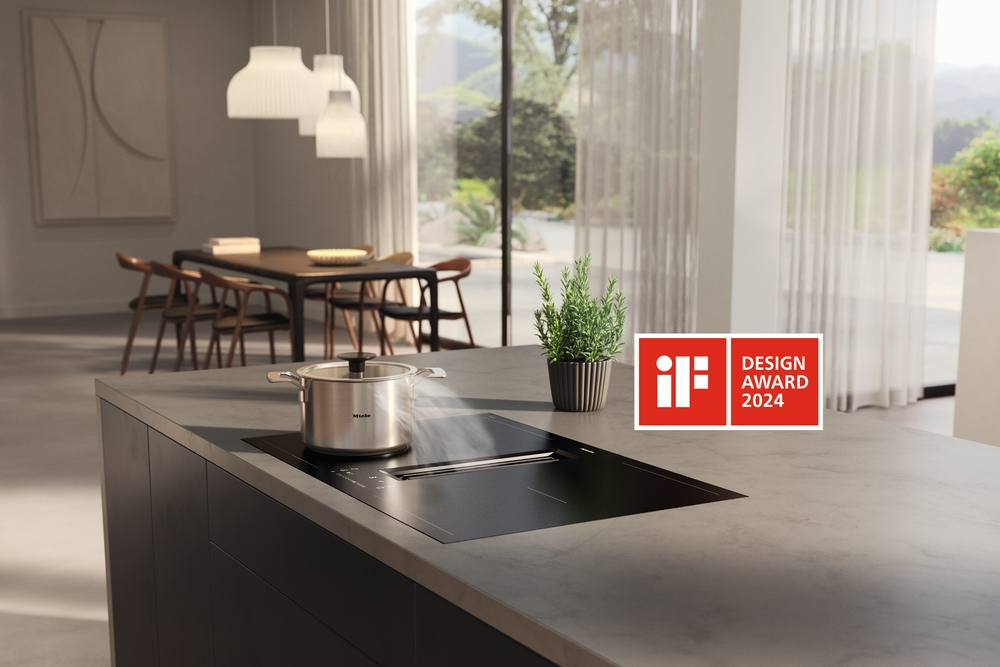 Moderne Kücheninsel mit Induktionskochfeld, Topf, Kräuterpflanze und IF Design Award 2024 Logo.