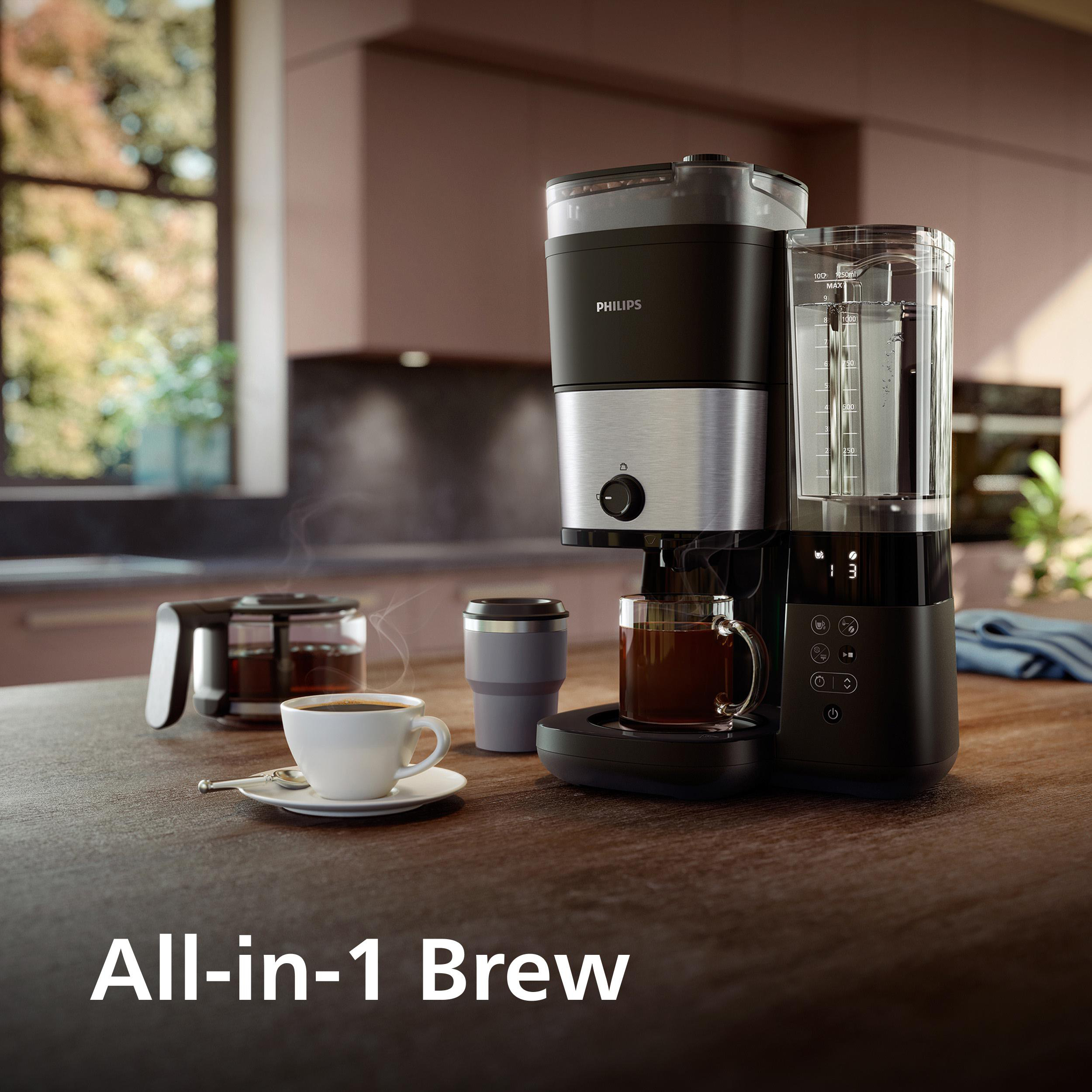 Kaffeemaschine brüht Kaffee in eine Tasse und einen Krug. Daneben eine Thermotasse.
