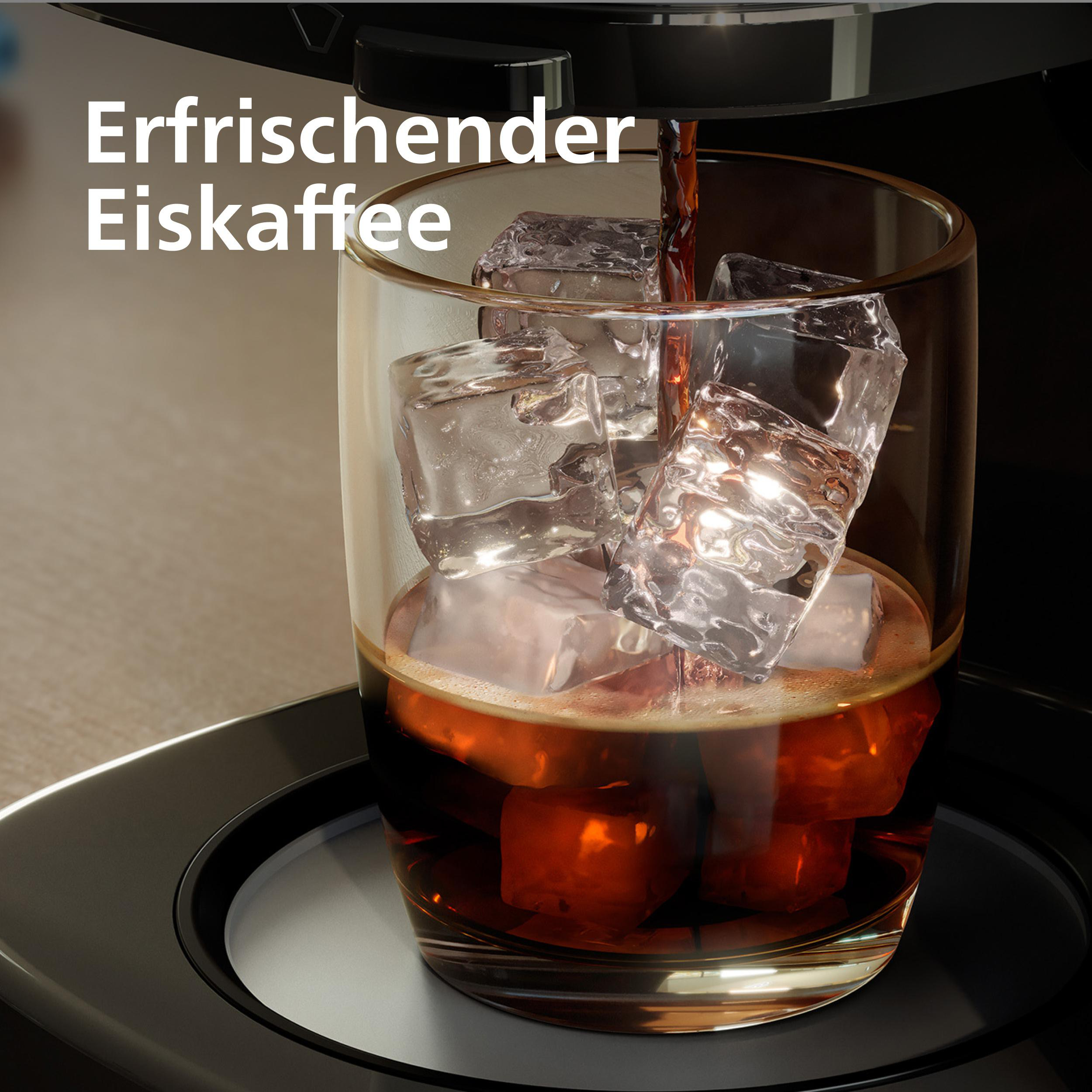 Eiswürfel in einem Glas mit brauner Flüssigkeit, die von oben hineingegossen wird.