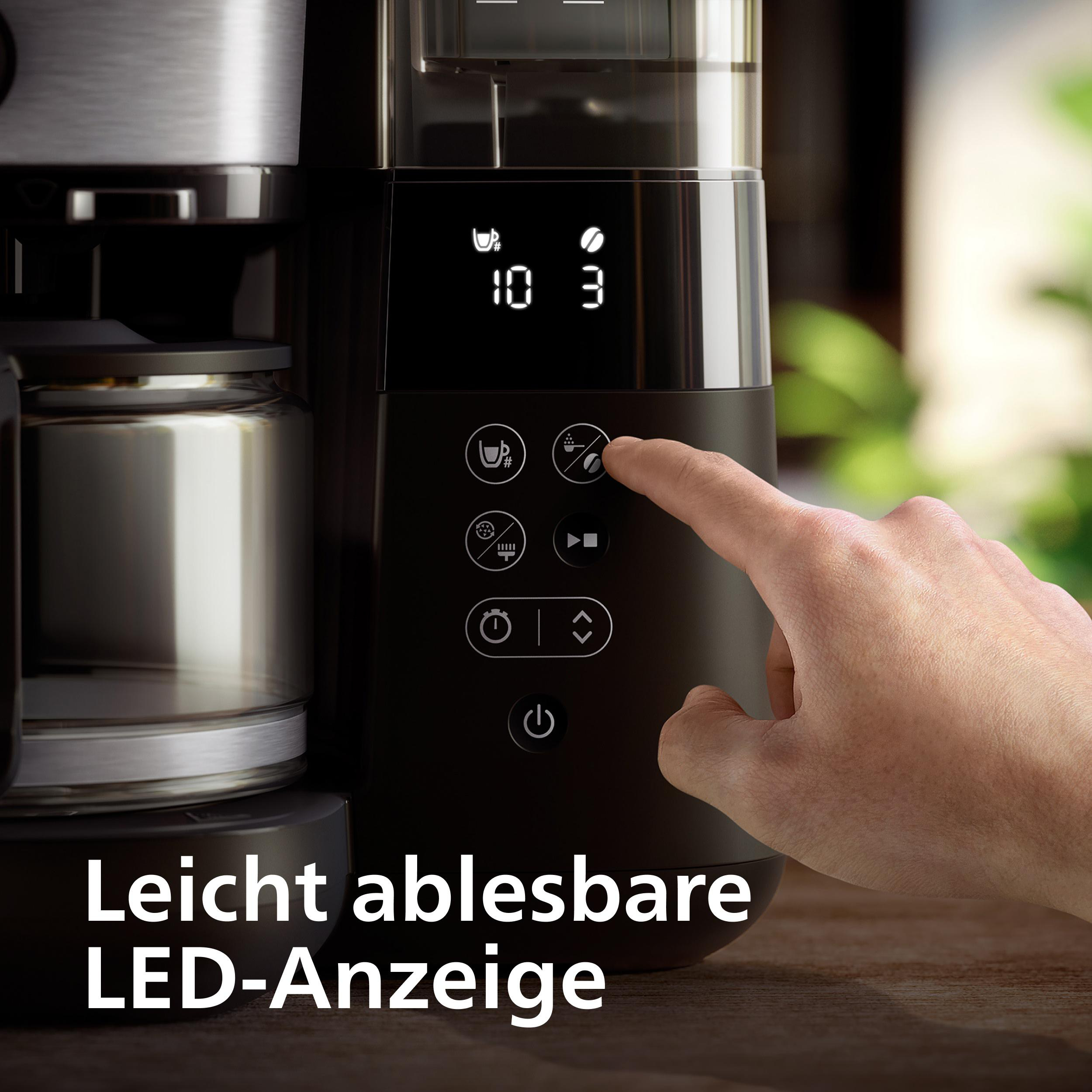 Eine Hand drückt auf das Kaffeebohnensymbol einer Kaffeemaschine mit LED-Anzeige.