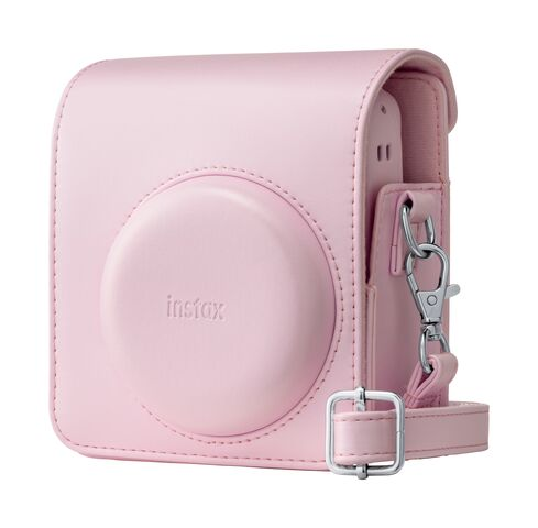 Różowe etui na aparat z logo "instax" i srebrnymi klamrami.