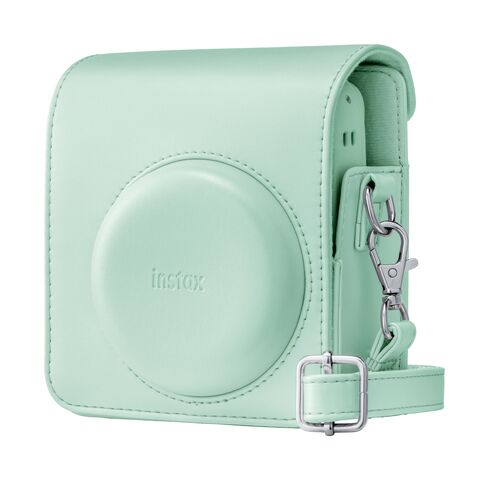Miętowo-zielona torba na aparat z logo Instax i srebrnymi klamrami.