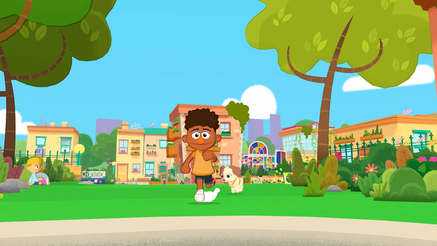 Un niño con un perro corre en un césped verde frente a casas coloridas.