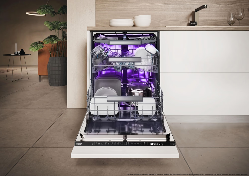 Eine offene Spülmaschine mit Geschirr, unter violettem Licht.