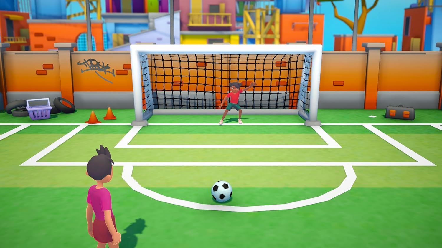 Ein Junge im Torwarttrikot schaut auf einen Ball vor einem Fußballtor, während ein anderes Kind davorsteht.